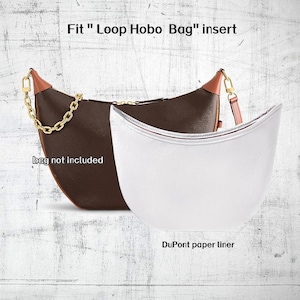 Könnte beinhalten: Eine braune und beige Hobo-Tasche mit goldenem Kettenriemen und weißem Einsatz. Der Text "Fit Loop Hobo Bag" und "bag not included" sind sichtbar. Der Einsatz ist mit "DuPont paper liner" beschriftet.