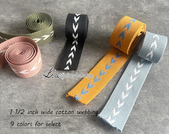 Könnte beinhalten: Fünf Spulen mit 3,8 cm breitem Baumwollband mit Chevron-Muster. Das Band ist in Schwarz, Grün, Hellblau, Gelb und Rosa. Der Text "Lia simpledesign" und "9 Farben zur Auswahl" ist sichtbar.