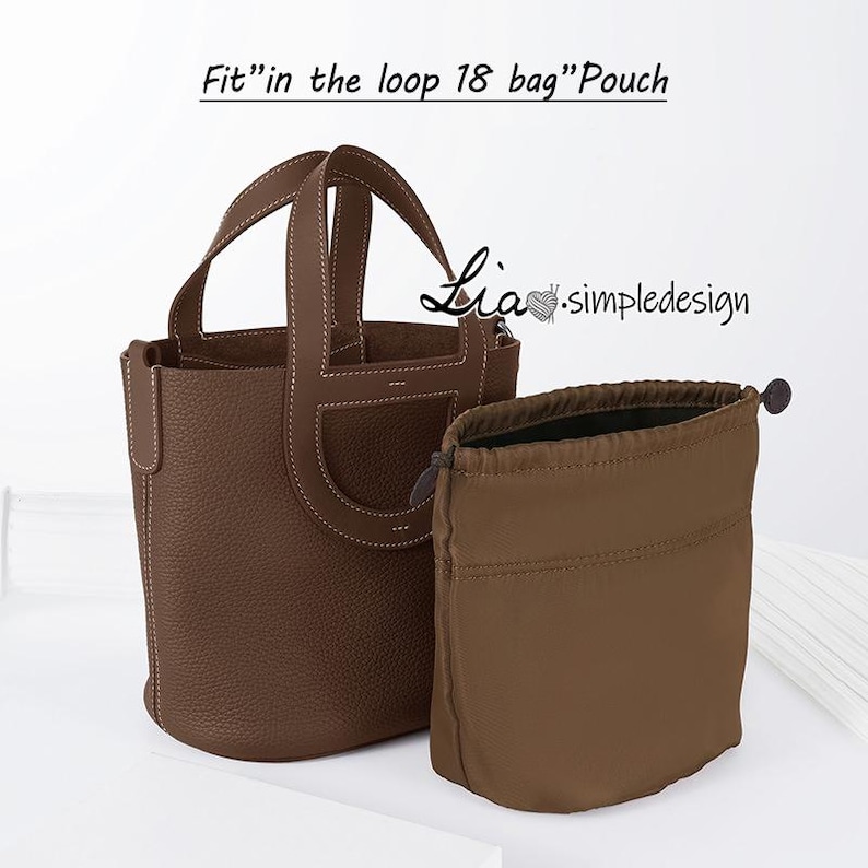 May include: A brown leather tote bag with a top handle and a drawstring pouch. The bag is labelled "Fit" in the loop 18 bag" Pouch. The pouch is brown and has a drawstring closure.