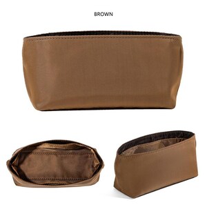 May include: A brown rectangular cosmetic bag with a dark brown interior. The bag is made of a smooth, matte material and has a simple, minimalist design. The word "BROWN" is printed at the top of the image.