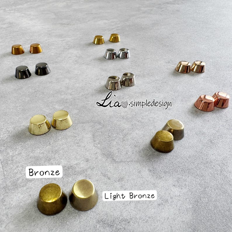 May include: A selection of metal cone-shaped rivets in gold, bronze, silver, and copper hues, arranged on a grey surface. The image features the text "Bronze" and "Light Bronze" near the rivets.