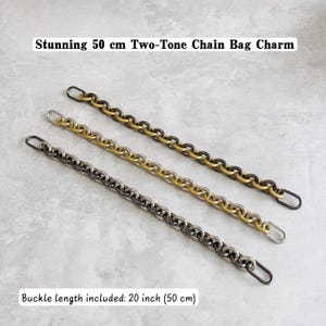 May include: Three 50 cm bag chains with oval end links. One chain is dark grey, one is gold-toned, and one is a two-tone mix of gold and dark grey. The text "Stunning 50 cm Two-Tone Chain Bag Charm" and "Buckle length included: 20 inch (50 cm)" is visible.