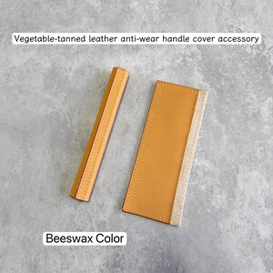 May include: Beeswax color vegetable-tanned leather anti-wear handle cover accessory. The accessory is a light brown color with yellow stitching. The text "Vegetable-tanned leather anti-wear handle cover accessory" and "Beeswax Color" are visible.