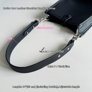 Könnte beinhalten: Schwarzer Leder-Schultergurt für eine Handtasche mit silberner Hardware. Der Gurt ist 53 cm lang und verstellbar. Der Gurt ist aus Kaviar-Rindsleder gefertigt und hat einen schwarzen Streifen in der Mitte.