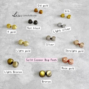 May include: An assortment of solid copper bag feet in different metallic shades, such as old gold, gun black, light silver, and rose gold. The image shows pairs of small, rounded feet, each labelled with its colour name.