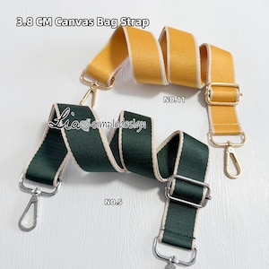 Op de afbeelding: Twee 3,8 cm canvas tasbanden met goudkleurige metalen hardware. De ene band is mosterdgeel en de andere is donkergroen. Beide hebben lichtbeige randen, verstelbare schuifgespen en karabijnhaken aan de uiteinden. Tekst: 3.8 CM Canvas Bag Strap.
