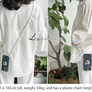 May include: A phone case with a silver chain worn across the body. The black phone case has a heart design. The model is wearing a white blouse and pants. The text "Lia simpledesign" is visible.