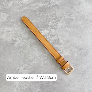 May include: An amber leather watch strap featuring a gold-toned metal buckle and two matching keepers. The strap has a series of pre-punched holes for adjustment and a width of 1.8 cm as indicated by the text label in the image.