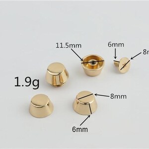 May include: Gold-coloured metal studs with measurements labelled. The studs are cone-shaped, with some having a flat top and others a rounded top. The weight is 1.9g. Dimensions are 6mm, 8mm, and 11.5mm.
