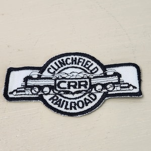May include: Black and white embroidered patch with a train engine and the text "Clinchfield Railroad" and "CRR".