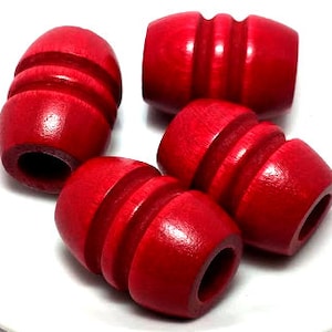 May include: Four red wooden beads with a grooved design. The beads are round and have a hole in the center.