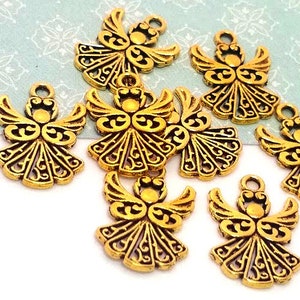 May include: Nine gold-tone metal angel charms with intricate designs. The charms are about the size of a US dime.
