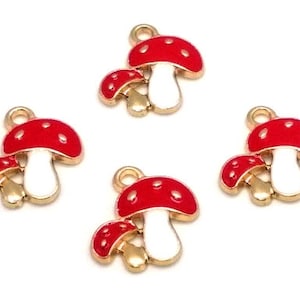 May include: Four gold-colored mushroom charms with red and white enamel. Each charm features a small mushroom with a larger mushroom on top.