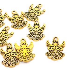 May include: Ten gold angel charms with intricate details. The charms are about the size of a US dime.