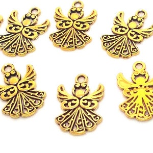 May include: Ten gold-toned metal angel charms with intricate designs. Each charm features a detailed angel with wings and a halo.