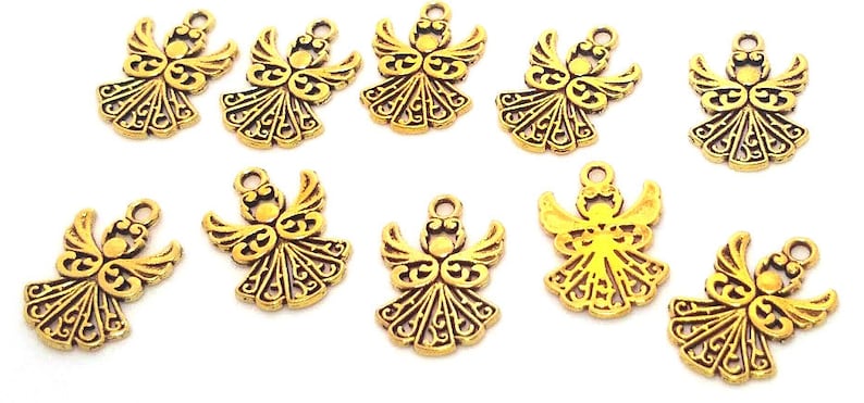 May include: Ten gold-toned metal angel charms with intricate designs. Each charm features a detailed angel with wings and a halo.