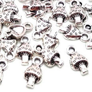 May include: A bulk pack of silver-toned mushroom charms with a dotted design. The charms have a loop at the top for attaching to jewelry or other crafts.