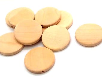May include: A collection of light-colored, circular wooden discs arranged in a cluster. Each flat, round piece features a smooth, natural grain finish and a small, centered hole drilled through the edge, suitable for various craft applications.