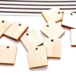 May include: A collection of ten unfinished, natural wood square tags with a hole in the center. The tags are perfect for crafting and adding a personalized touch to gifts or projects.
