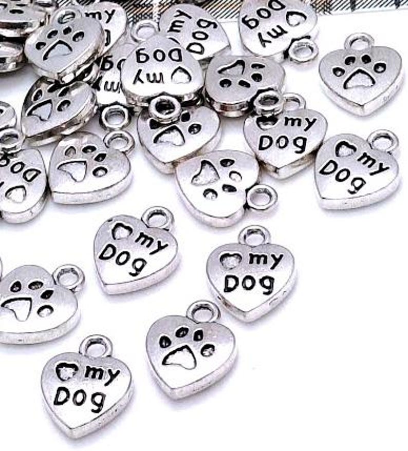 May include: Silver heart-shaped charms with the words "my dog" and a paw print design.
