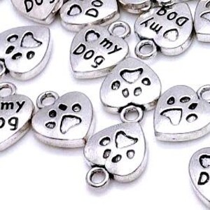May include: Silver heart-shaped charms with the words "I love my dog" and paw prints.