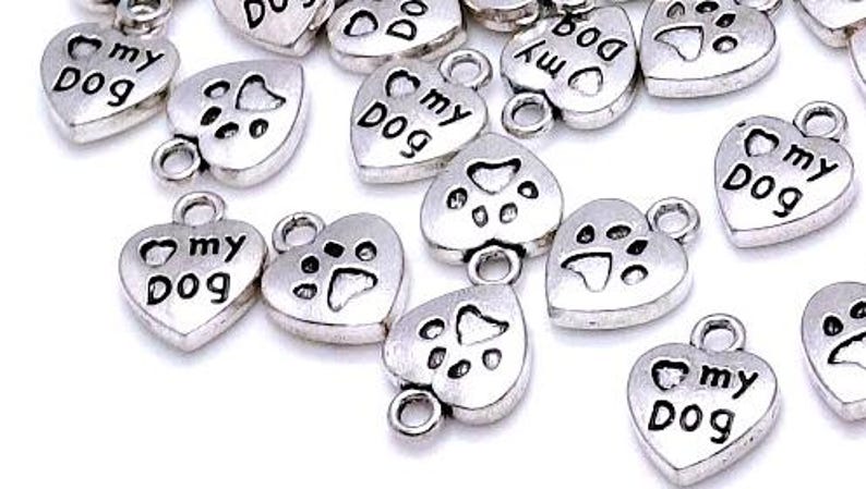 May include: Silver heart-shaped charms with the words "I love my dog" and paw prints.