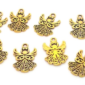 May include: Ten gold-colored angel charms with intricate details. The charms are about the size of a US quarter.