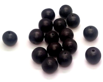 May include: A collection of fifteen spherical beads with a dark brown, matte finish. Each bead features a small, centered hole drilled through the middle, allowing for stringing. The beads are arranged in a loose cluster on a plain surface.
