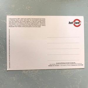 Pode incluir: Um cart&atilde;o postal branco com texto sobre Broadwater Farm Estate em Tottenham, North London, e um logotipo "hotstamp" vermelho e branco. O cart&atilde;o postal est&aacute; sobre uma superf&iacute;cie texturizada azul clara.