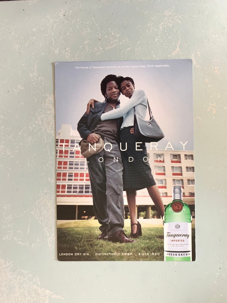 Pode incluir: Um an&uacute;ncio de Tanqueray London Dry Gin. A imagem apresenta duas pessoas a abra&ccedil;ar-se, com uma garrafa de gin em primeiro plano. O texto diz: "The House of Tanqueray reminds you to be a good chap. Drink responsibly."