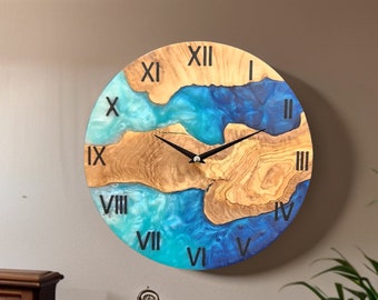 May include: A round wooden clock with Roman numeral markings and blue and turquoise resin accents. The clock face is made of wood with a natural grain pattern.