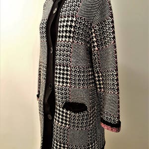 Cardigan tricoté noir/blanc/rose avec damiers à motifs.