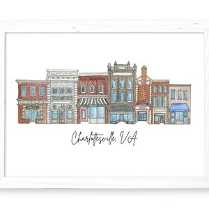 May include: Watercolor illustration of a row of brick buildings with storefronts in a downtown area. The buildings are in various shades of red, brown, and gray. The text "Charlottesville, VA" is written below the buildings.