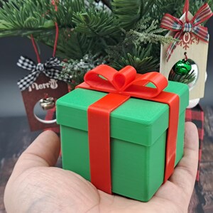 gift card holder box held by hand in front of small Christmas tree