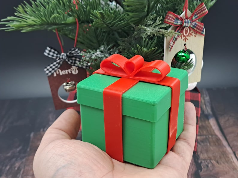 gift card holder box held by hand in front of small Christmas tree
