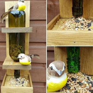 May include: A wooden bird feeder with two glass bottles filled with birdseed. The feeder has two platforms for birds to perch on and a tray at the bottom for more seed. Two small, yellow and brown birds are perched on the feeder.