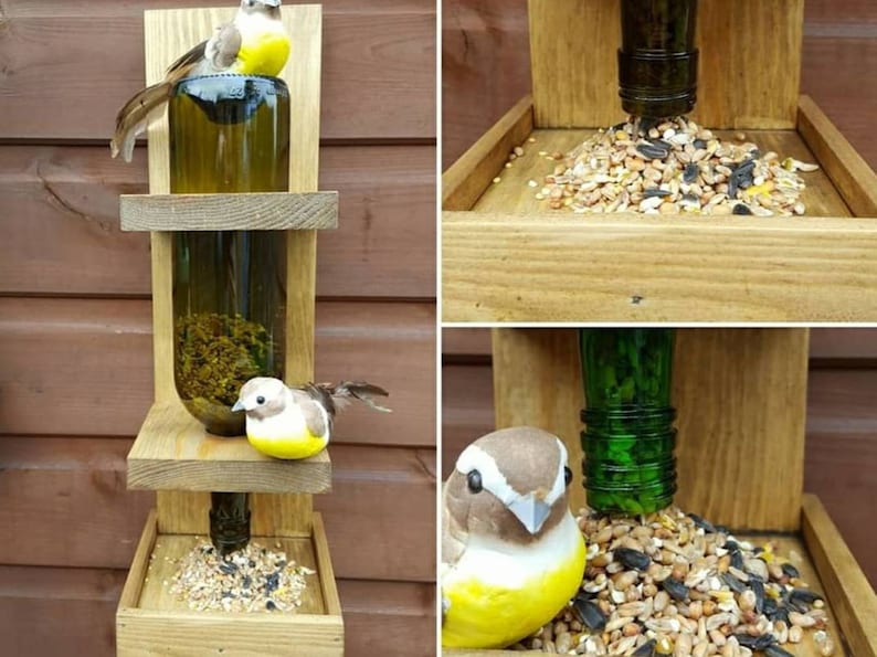 May include: A wooden bird feeder with two glass bottles filled with birdseed. The feeder has two platforms for birds to perch on and a tray at the bottom for more seed. Two small, yellow and brown birds are perched on the feeder.