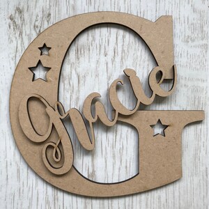 Carta de madera personalizada con nombre de guión y estrellas.