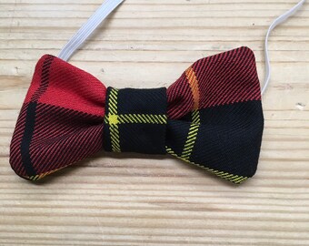 Könnte beinhalten: Ein rotes, gelbes und schwarzes Karoband mit einem Gummiband.