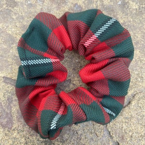 Puede incluir: Un scrunchie para el pelo de cuadros rojos y verdes.