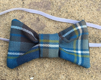 May include: A blue, brown, and white plaid bow tie with an elastic band.