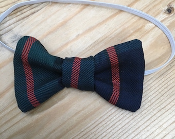 Könnte beinhalten: Eine dunkelgrüne und rot gestreifte Fliege mit Gummiband.