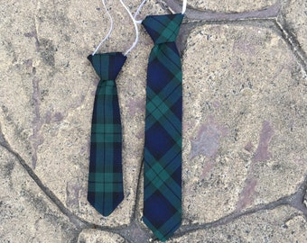 May include: Two plaid ties, one blue and green and one smaller green and black, with white elastic bands.