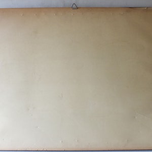 May include: A plain, off-white picture frame with a light brown wooden border. The frame is empty and ready to be filled with a picture or artwork.