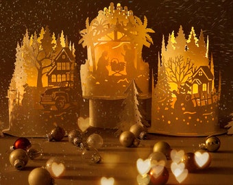 May include: Three white paper Christmas lanterns with intricate cut-out designs. The lanterns depict winter scenes with trees, houses, and a nativity scene. The lanterns are illuminated from within, casting a warm glow.