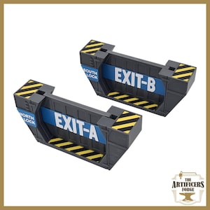 Puede incluir: Dos estructuras rectangulares grises con texto azul y blanco que dice "EXIT-A" y "EXIT-B". Las estructuras tienen rayas diagonales amarillas y negras. El texto "NORTH LOCK" y "SOUTH LOCK" también es visible.
