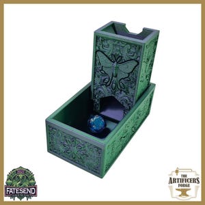 May include: Green wooden dice tower with a butterfly design and a matching tray. The tower has a slot for dice to roll through. A blue and green die is in the tray. The tower is decorated with floral patterns.