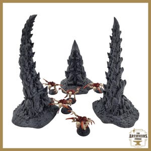 Könnte beinhalten: Ein Set aus 3D-gedruckten Miniatur-Geländestücken für Tabletop-Spiele. Das Set enthält zwei hohe, stachelige, schwarze Strukturen und mehrere kleinere, rote und schwarze Kreaturen. Die Strukturen erinnern an außerirdische oder Fantasy-Architektur. Die Kreaturen erinnern an Insekten oder Spinnen.
