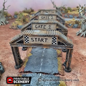 Könnte beinhalten: Ein Satz von vier verwitterten, hölzernen und metallenen Rennstreckentoren mit schwarz-weißen Schachbrettflaggen. Die Tore sind mit "Start", "Gate 1", "Gate 2" und "Finish" beschriftet.