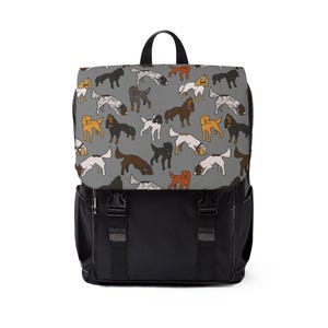 Pode incluir: Uma mochila preta com um padrão cinza de cães de várias cores. Os cães estão todos em poses diferentes e olhando em direções diferentes. A mochila tem duas alças ajustáveis e um fecho de correr.